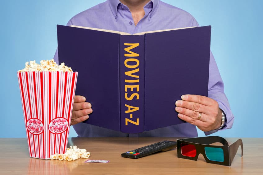 A Man Sat At A Table Reading A Movies A Z Book
